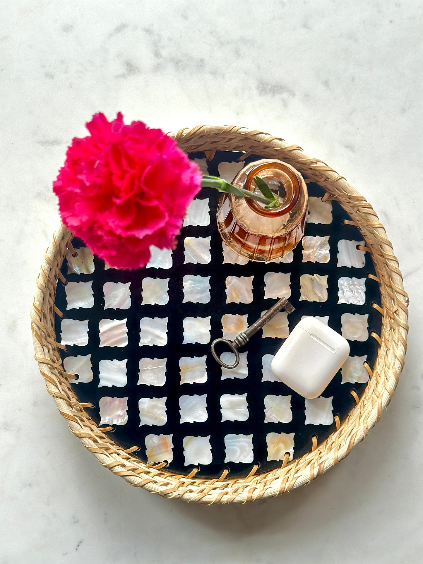 small handmade mother of pearl inlay and rattan tray with a vase and other trinkets
