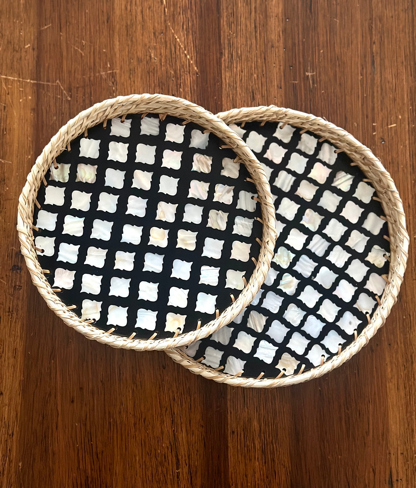 set of 2 round mother of pearl inlay and rattan trays with a monochromatic abstract design