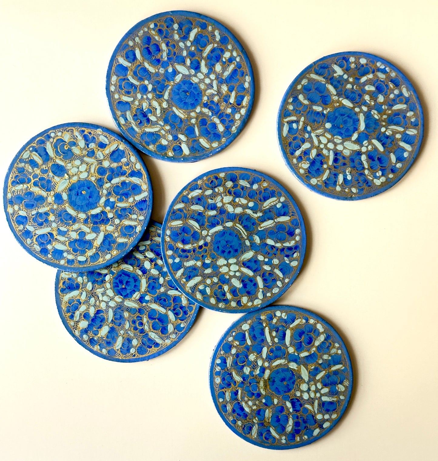6 blue and gold hand-painted paper-mache coasters in a floral design