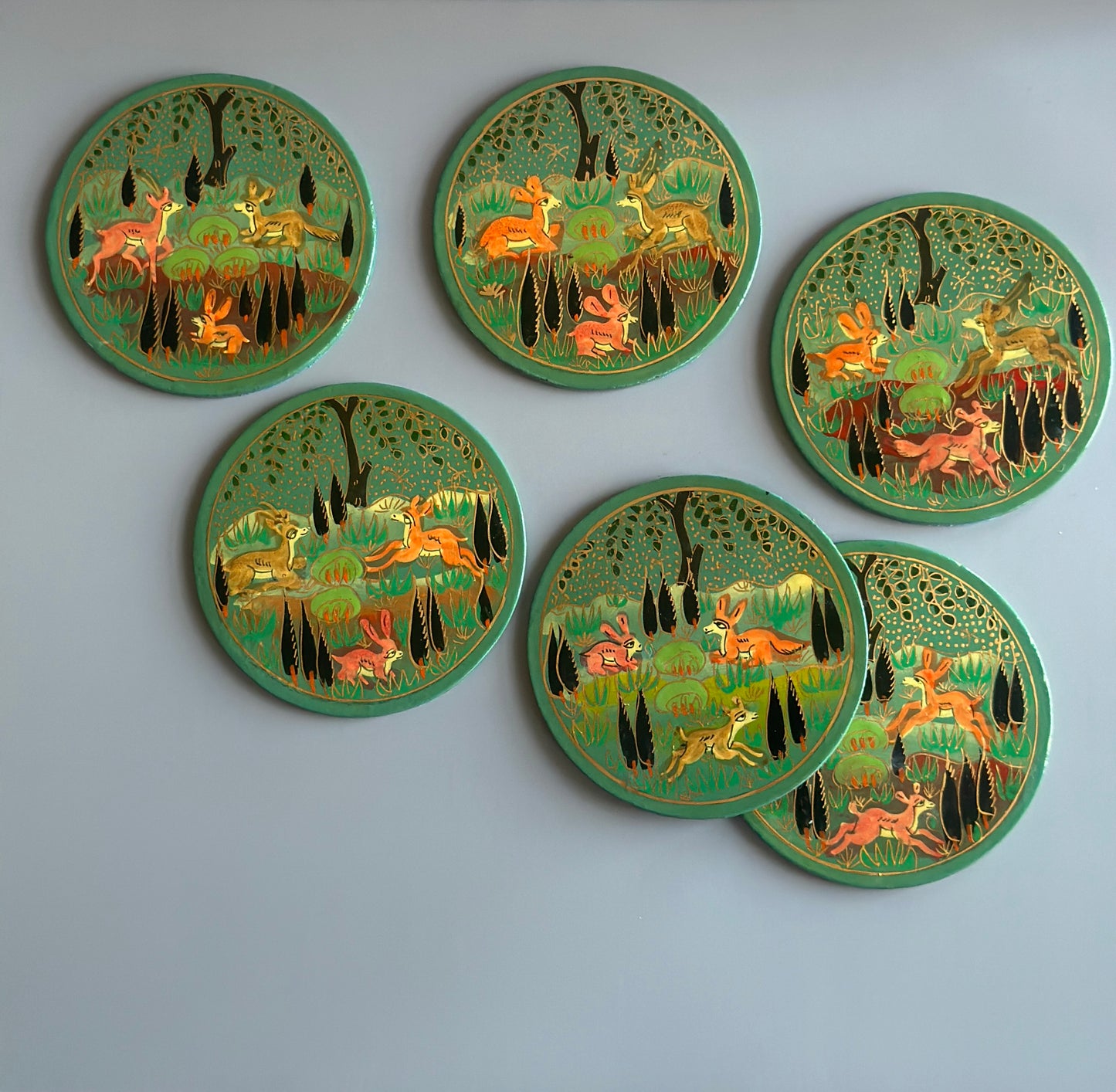 6 blue and gold hand-painted paper-mache coasters with jungle motifs