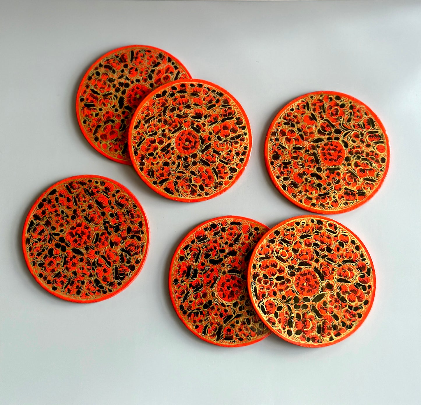 6 bright red and gold hand-painted paper-mache coasters in a floral design