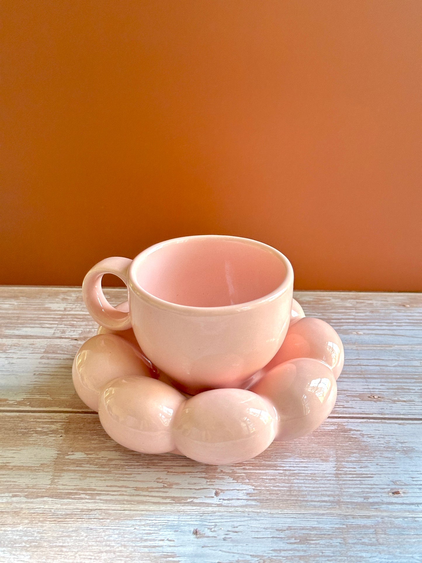 Pastel pink ceramic cup and saucer set with a unique chubby design handmade by artisans