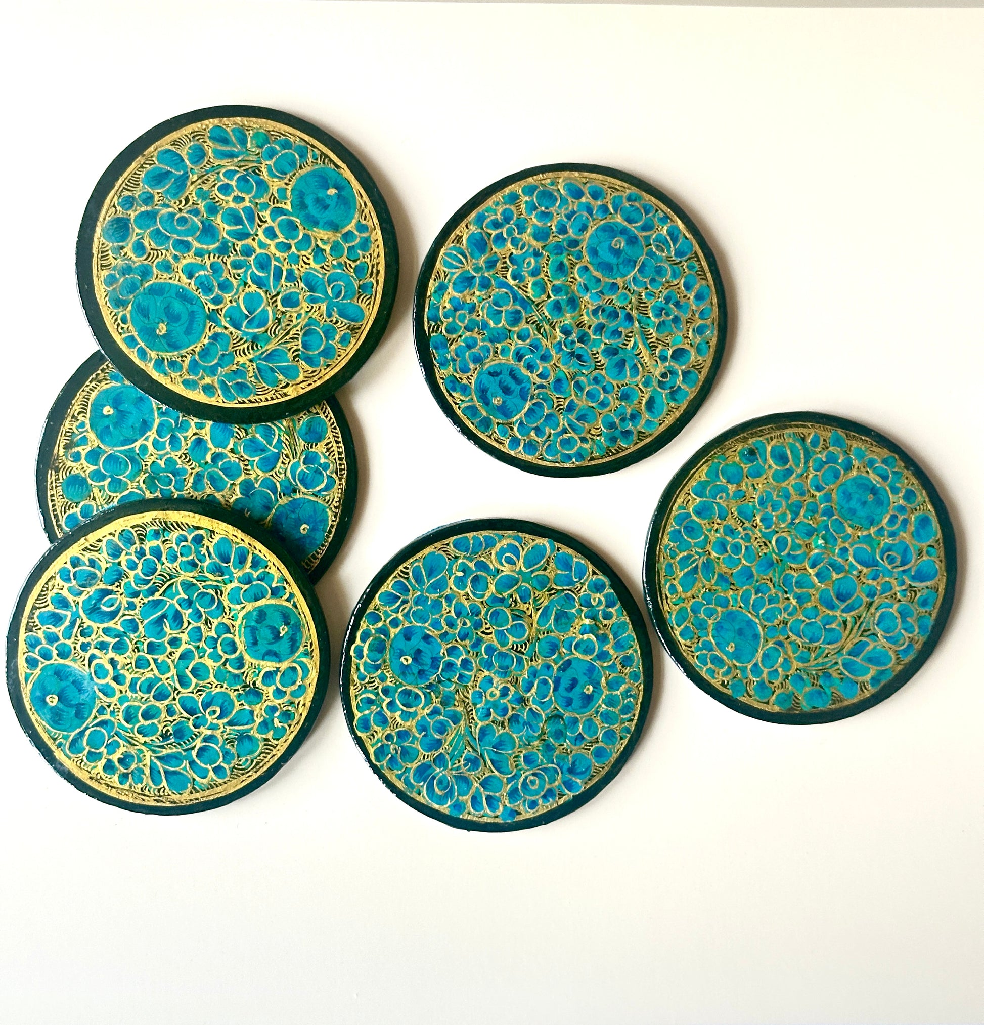 6 teal blue and gold hand-painted paper-mache coasters in a floral design