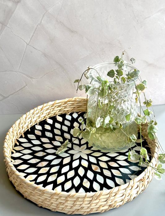 small round mother of pearl inlay tray in monochrome with rattan woven edges and a petal pattern