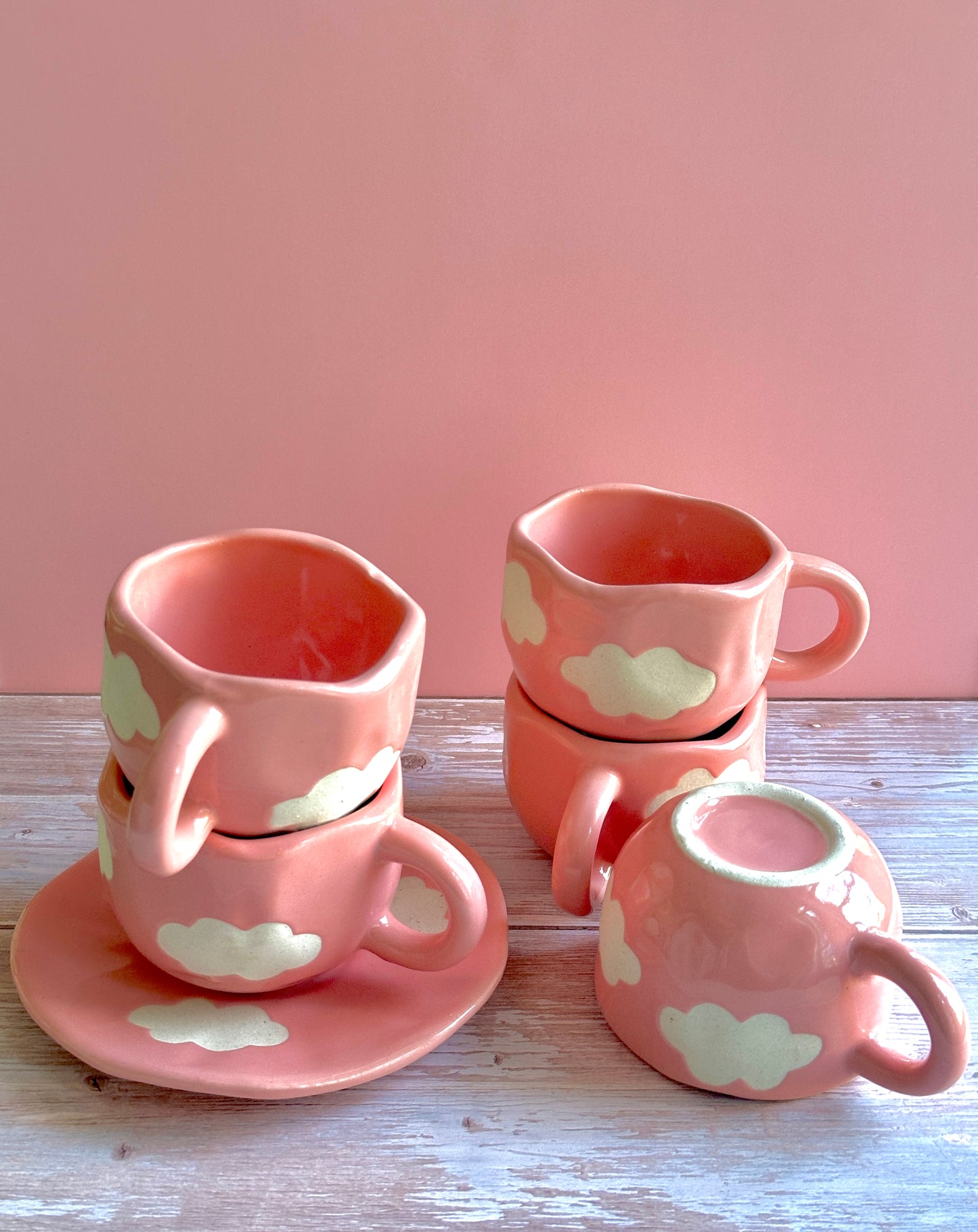 Pink handmade and hand-painted ceramic cups and saucers with cloud motifs