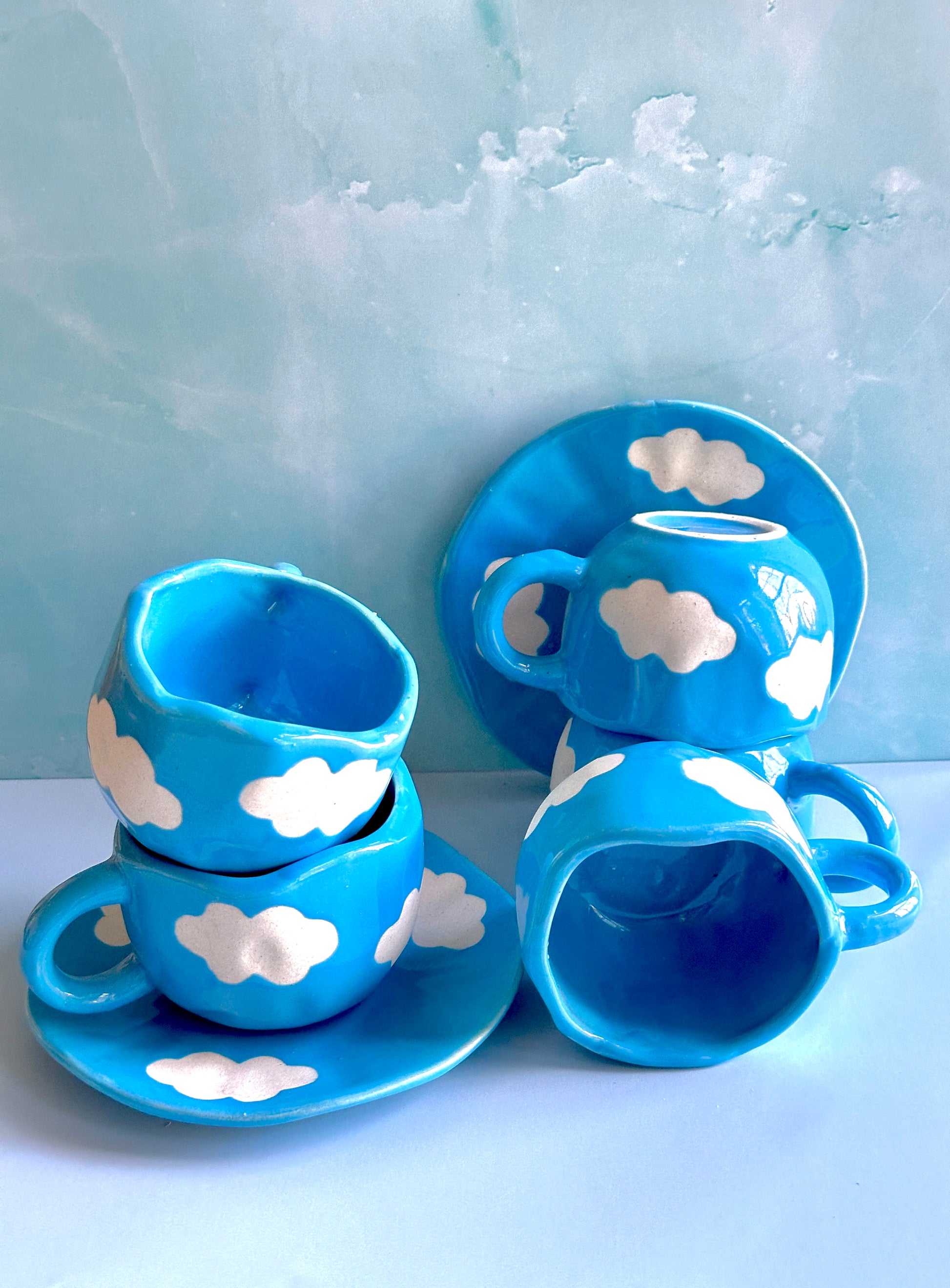 Blue handmade and hand-painted ceramic cups and saucers with cloud motifs