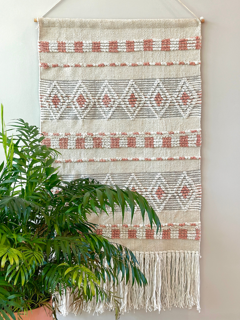 beautiful handmade wall tapestry in neutral hues and fringe at the bottom