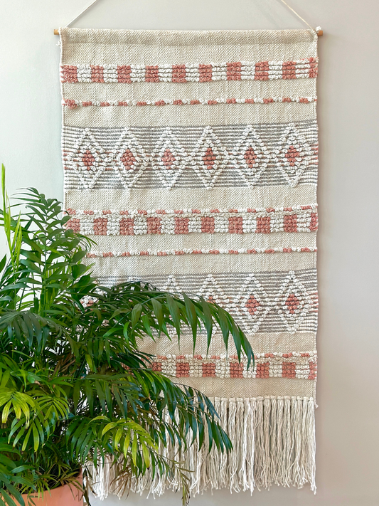 beautiful handmade wall tapestry in neutral hues and fringe at the bottom