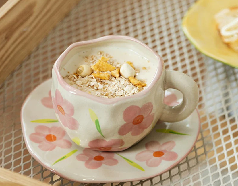 Pink floral handmade ceramic cup filled with coffee